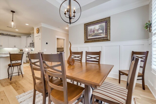 dining area featuring light hardwood / wood-style flooring, crown molding, a wealth of natural light, and a notable chandelier