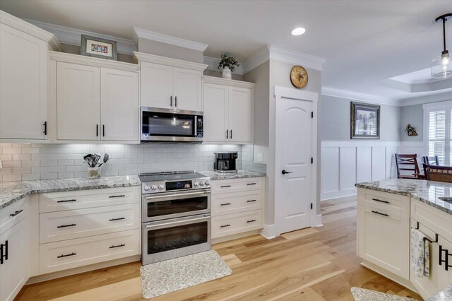 kitchen featuring backsplash, stainless steel appliances, and white cabinetry