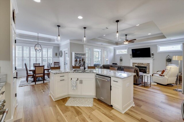 kitchen featuring white cabinetry, dishwasher, sink, hanging light fixtures, and a tray ceiling