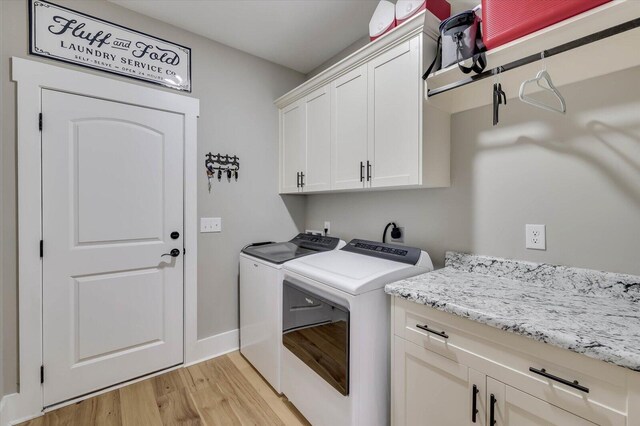 clothes washing area featuring light hardwood / wood-style floors, cabinets, and independent washer and dryer