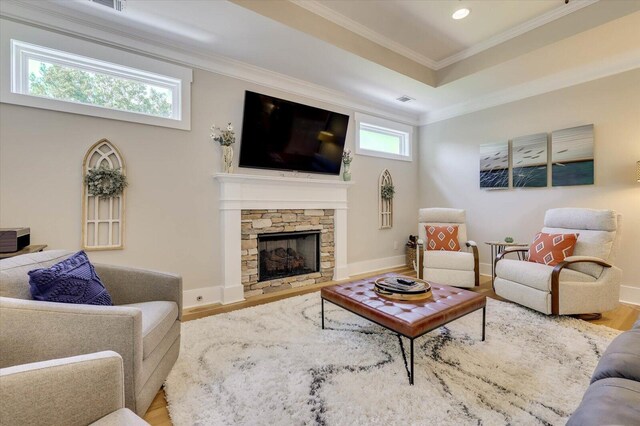 living room featuring hardwood / wood-style floors, a fireplace, and crown molding