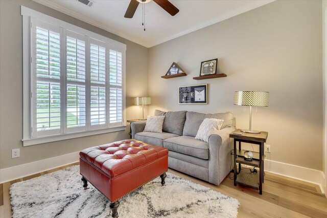 living room featuring light hardwood / wood-style floors, ceiling fan, and crown molding