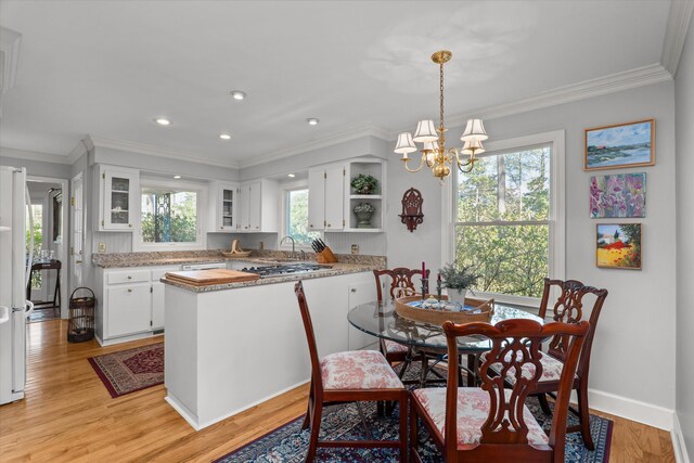 dining area with plenty of natural light, light wood-style floors, and ornamental molding