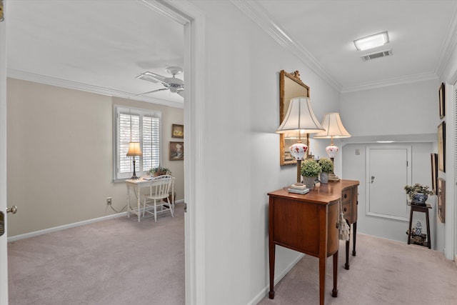 hallway with visible vents, baseboards, carpet, and ornamental molding