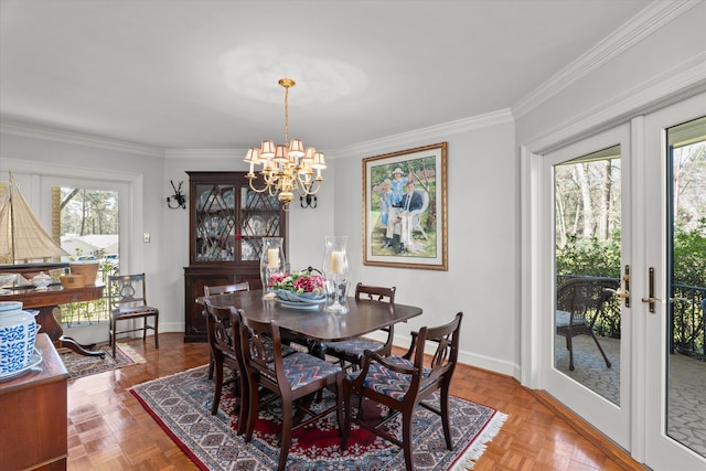 dining room with a wealth of natural light, a chandelier, french doors, and ornamental molding