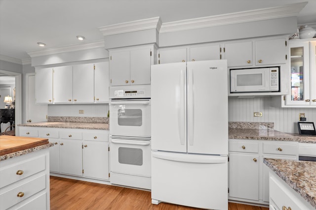 kitchen with white appliances, recessed lighting, ornamental molding, white cabinets, and light wood-type flooring