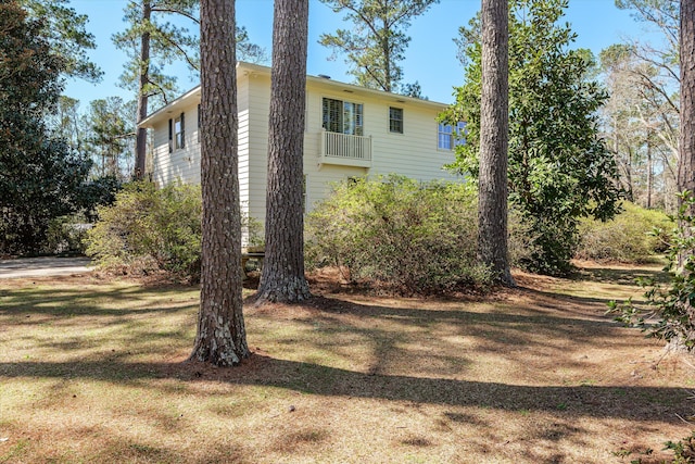 exterior space featuring a balcony and a lawn