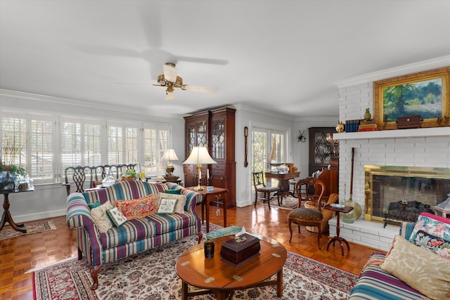 living room featuring ceiling fan, a brick fireplace, baseboards, and ornamental molding