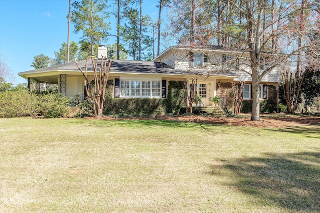 view of front of home with a chimney and a front lawn