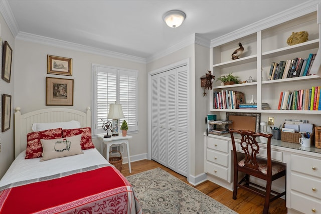 bedroom featuring ornamental molding, wood finished floors, a closet, and built in study area