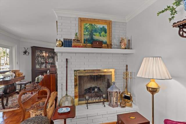 living room featuring a brick fireplace, crown molding, and wood finished floors