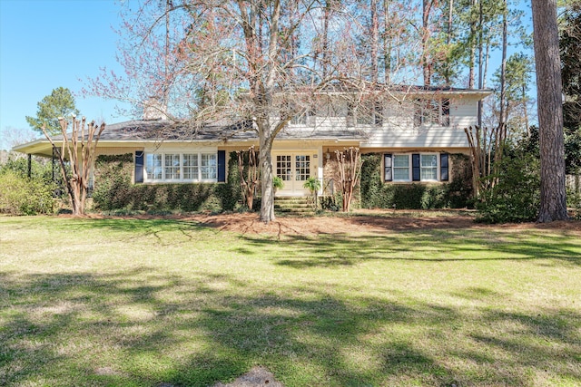 view of front of home with a front yard, french doors, and brick siding