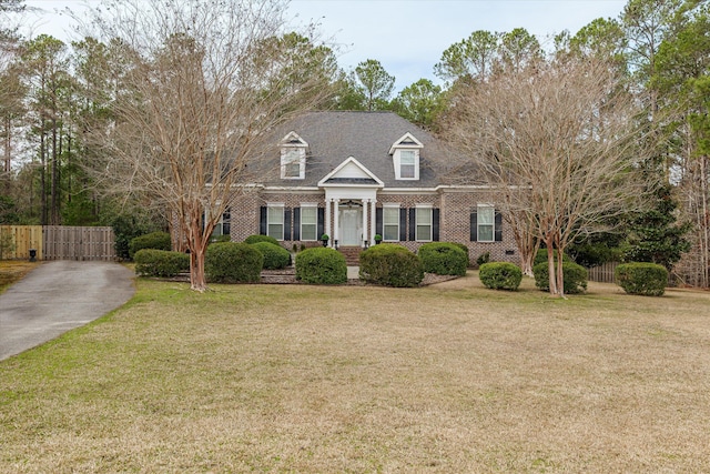 cape cod house with a front yard