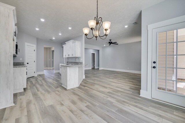 kitchen featuring ceiling fan with notable chandelier, sink, light hardwood / wood-style floors, white cabinetry, and hanging light fixtures