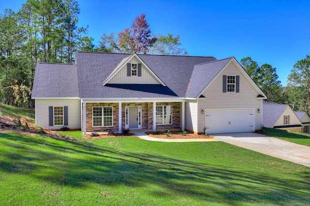 view of front of home with covered porch, a garage, and a front lawn