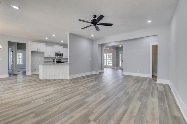 unfurnished living room with light hardwood / wood-style floors and ceiling fan