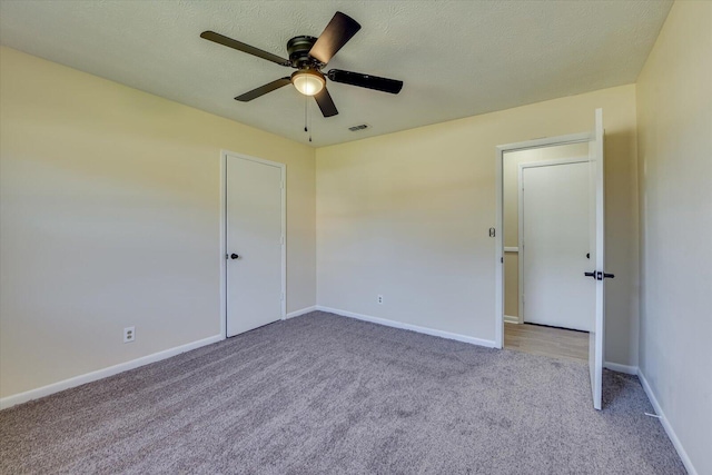 unfurnished bedroom with baseboards, a textured ceiling, visible vents, and carpet flooring