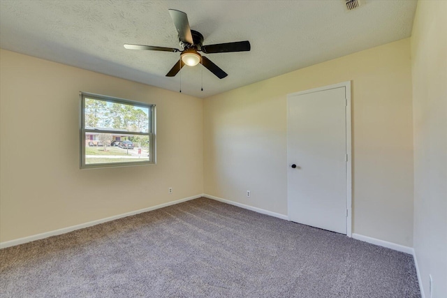 unfurnished room with carpet, ceiling fan, a textured ceiling, and baseboards