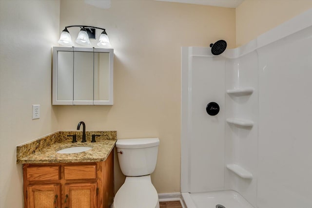 bathroom featuring a shower, vanity, and toilet