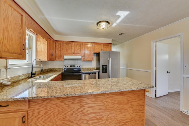 kitchen featuring appliances with stainless steel finishes, ornamental molding, a sink, a peninsula, and under cabinet range hood