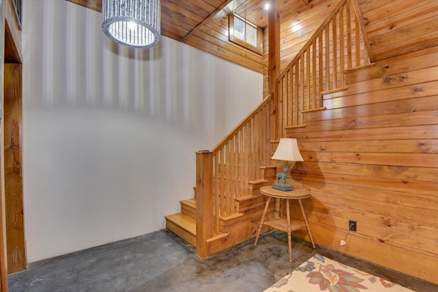 stairs with concrete floors and wooden walls