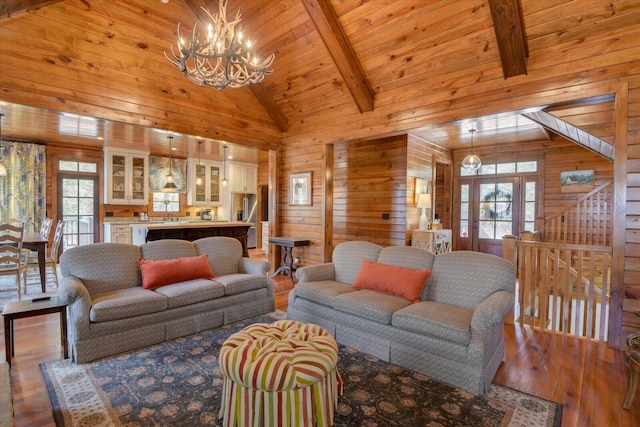 living area with a wealth of natural light, wooden walls, and hardwood / wood-style flooring