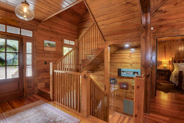 foyer with wooden ceiling, a sauna, stairway, wood finished floors, and wood walls