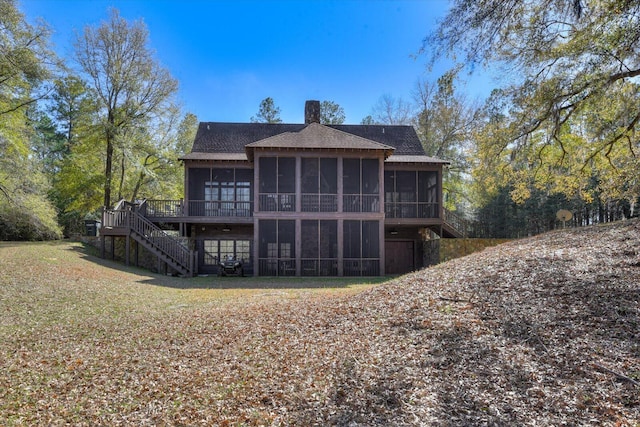 back of house with stairway, a sunroom, a yard, and a chimney