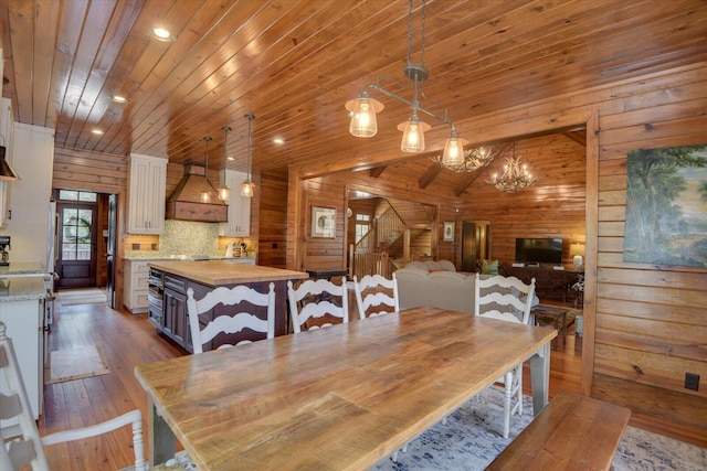 dining space featuring wooden ceiling, a notable chandelier, wooden walls, and hardwood / wood-style flooring