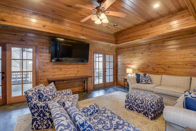 living area with wooden walls, a ceiling fan, wooden ceiling, french doors, and concrete floors