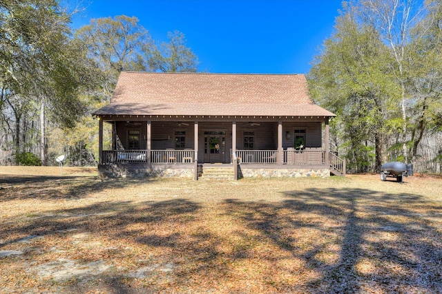 view of front of house with covered porch, roof with shingles, and ceiling fan