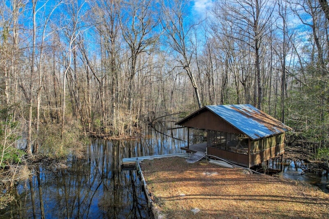 dock area with a water view and a wooded view