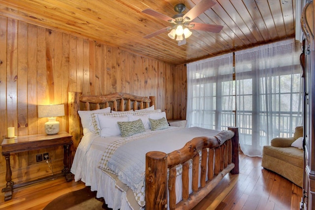 bedroom with wood ceiling, wooden walls, and hardwood / wood-style floors