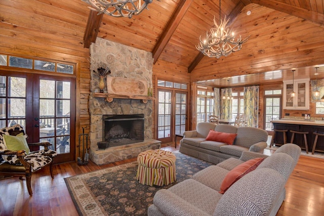 living room with a chandelier, french doors, and wooden walls