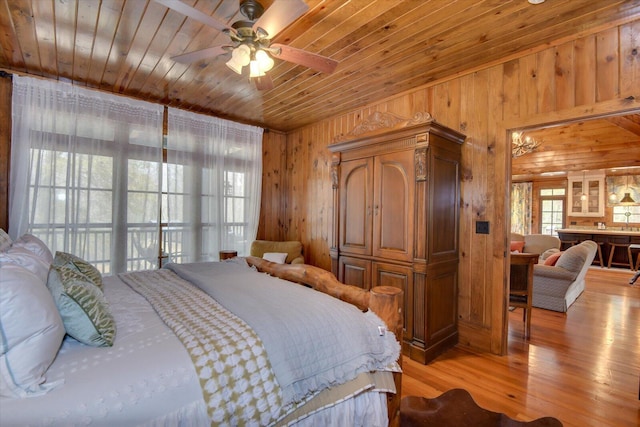 bedroom with wooden ceiling, wood walls, and light wood-style flooring