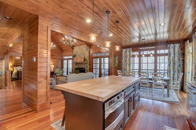 kitchen with butcher block countertops, wooden ceiling, vaulted ceiling, and light wood finished floors