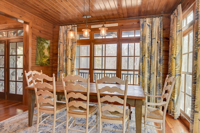 unfurnished dining area with wood walls, wood ceiling, light wood-style flooring, and french doors