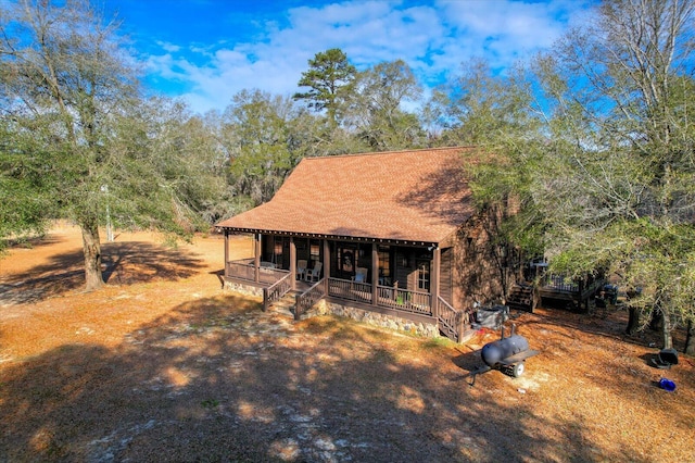 rustic home with a porch and a shingled roof