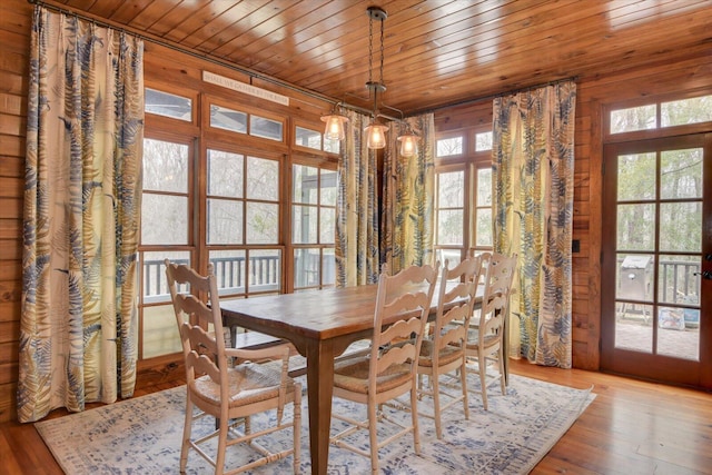 dining room with a wealth of natural light, wood ceiling, and wood finished floors