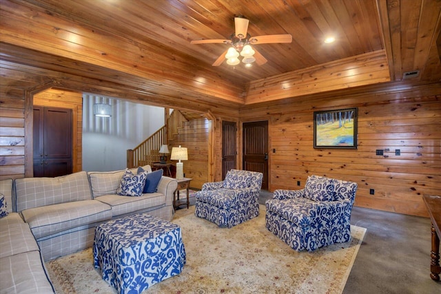 living room featuring stairs, wood walls, wood ceiling, and a ceiling fan