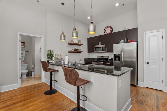 936 Broad St # 415, Augusta, GA 30901 - kitchen featuring a sink, stainless steel appliances, high vaulted ceiling, light wood-type flooring, and a breakfast bar
