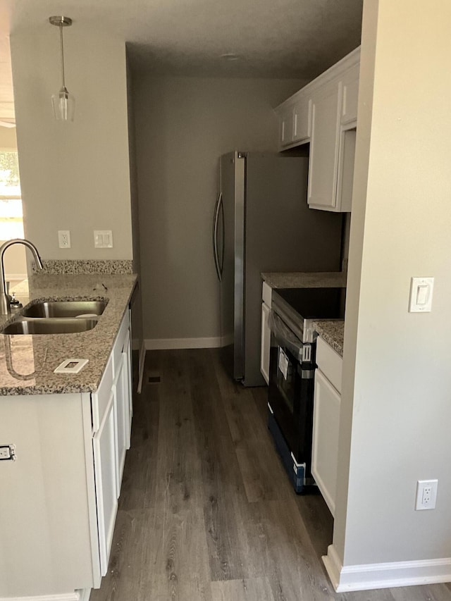 kitchen with black range with electric stovetop, light stone countertops, sink, pendant lighting, and white cabinets