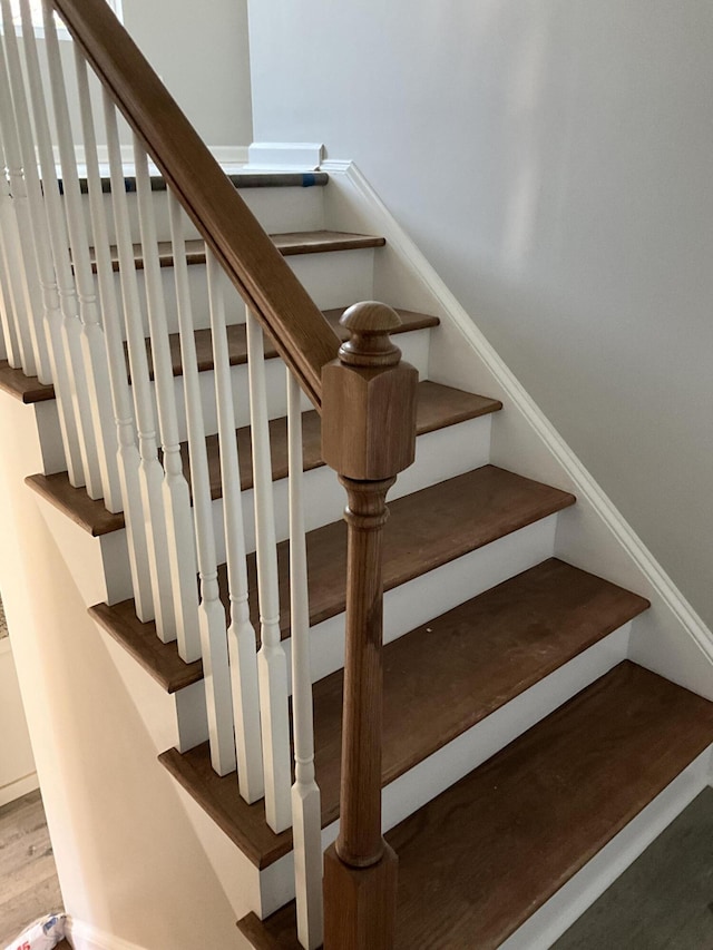 stairs featuring hardwood / wood-style floors