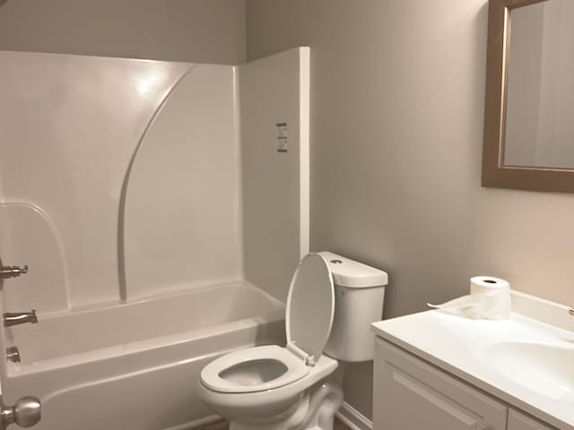 full bathroom featuring vanity, bathtub / shower combination, and toilet