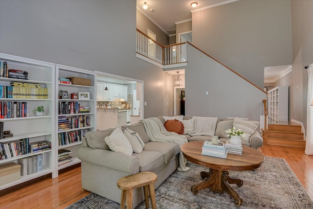 207 Oleander Trl, Evans, GA 30809 - living room with light wood-type flooring, stairway, crown molding, and a towering ceiling