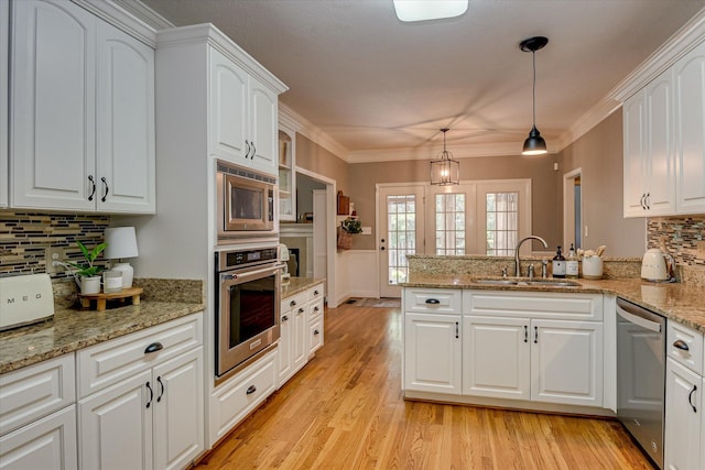207 Oleander Trl, Evans, GA 30809 - kitchen featuring appliances with stainless steel finishes, a peninsula, backsplash, white cabinets, and ornamental molding