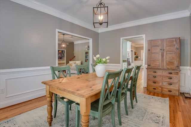 207 Oleander Trl, Evans, GA 30809 - dining space featuring crown molding, light wood-type flooring, a wainscoted wall, and a chandelier