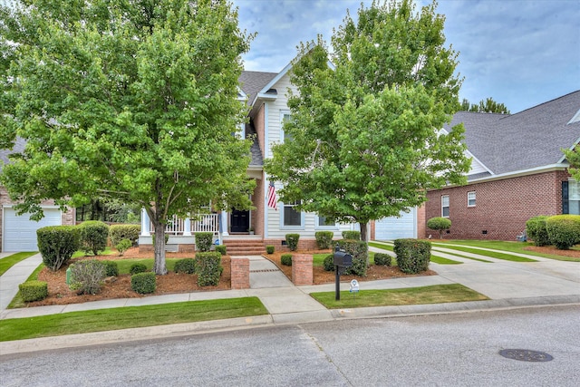 207 Oleander Trl, Evans, GA 30809 - obstructed view of property with roof with shingles, covered porch, a garage, concrete driveway, and brick siding