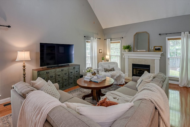 207 Oleander Trl, Evans, GA 30809 - living area with wood finished floors, healthy amount of natural light, a tiled fireplace, and high vaulted ceiling