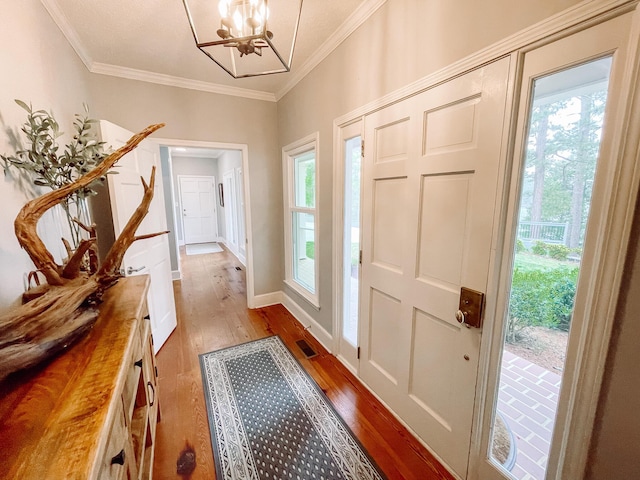 228 Heron Shrs, Mccormick, SC 29835 - foyer entrance featuring an inviting chandelier, wood-type flooring, plenty of natural light, ornamental molding, and visible vents